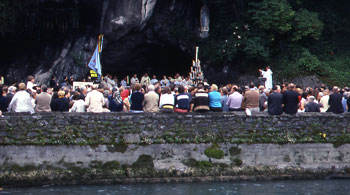 ▲洞窟の前に集まる人々。中央上にみえるのが白いマリア像。